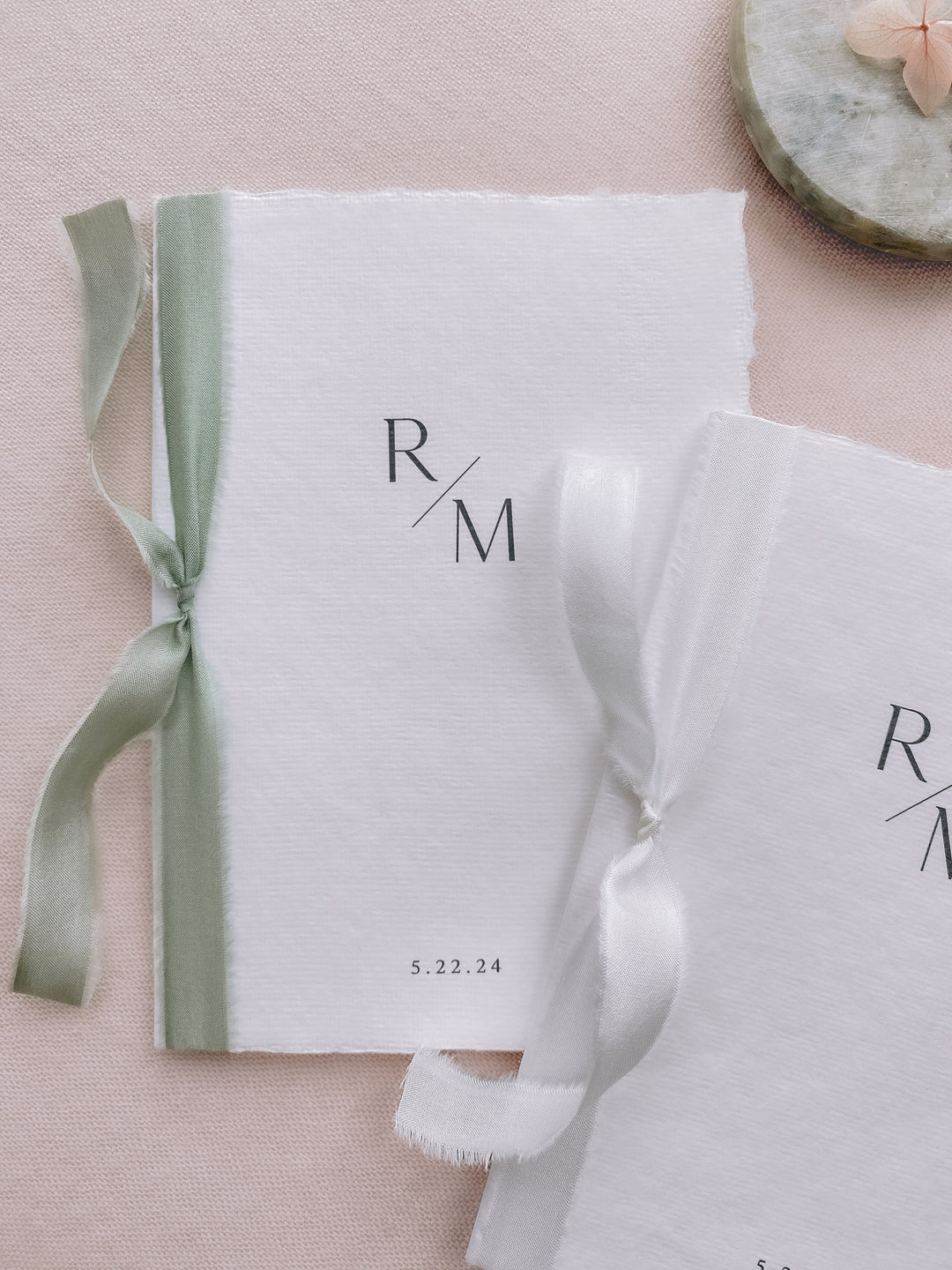 custom initials white handmade paper wedding vow books tied in sage green and white silk ribbons