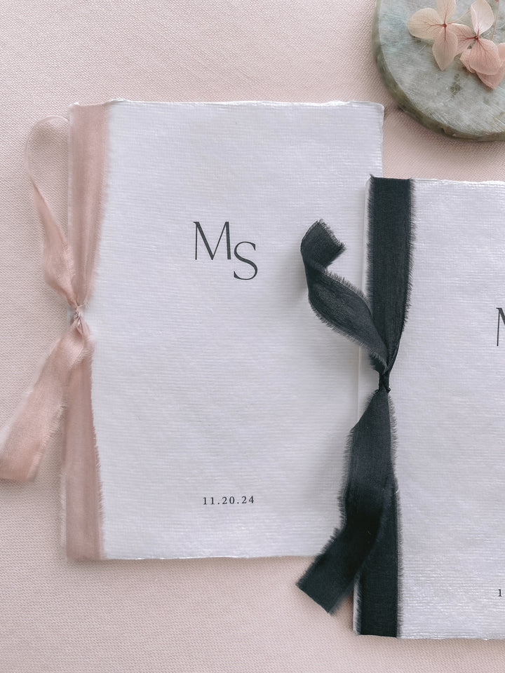 personalized initials white handmade paper wedding vow books tied in pink and black silk ribbons