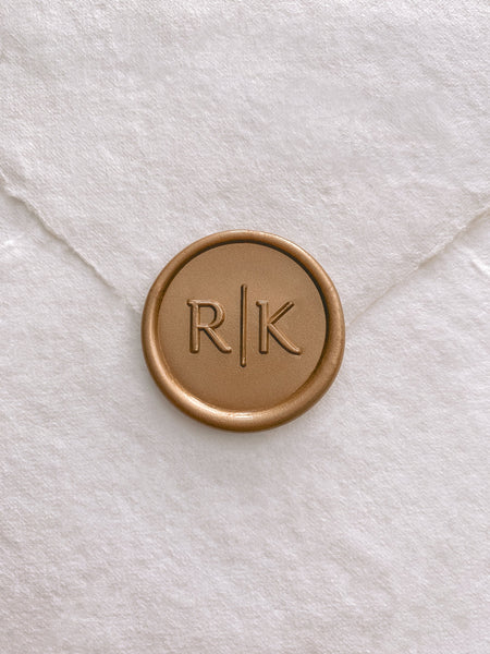 Modern typeface monogram custom wax seal in gold on beige handmade paper envelope