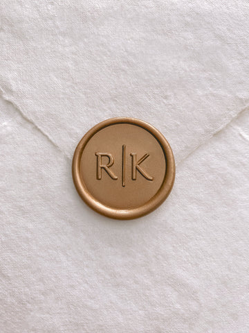 Modern typeface monogram gold custom wax seal on beige handmade paper envelope