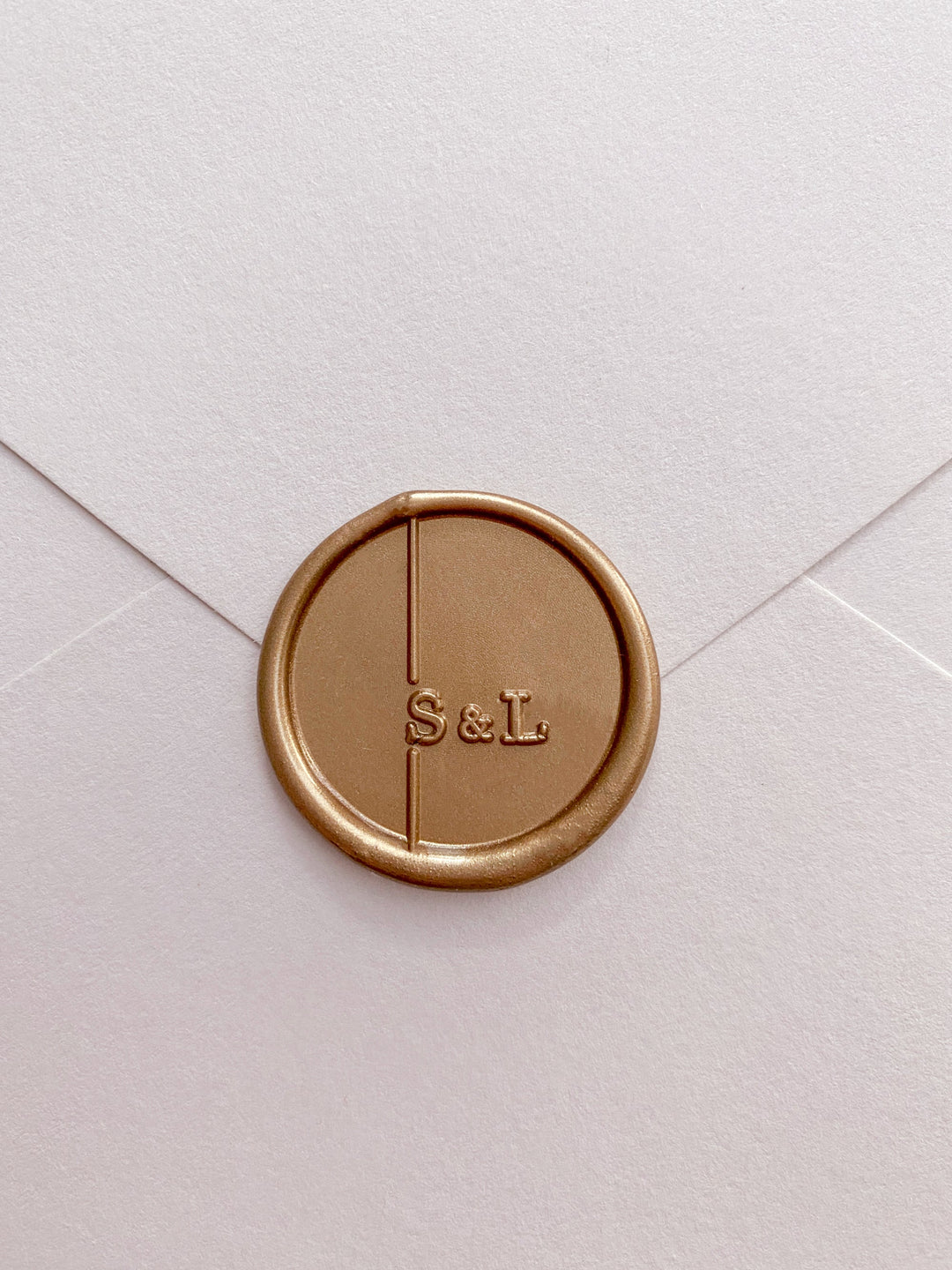 Modern monogram custom wax seal in gold on envelop front view