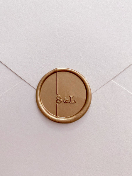 Moderne monogram wax seal in gold on envelop front view