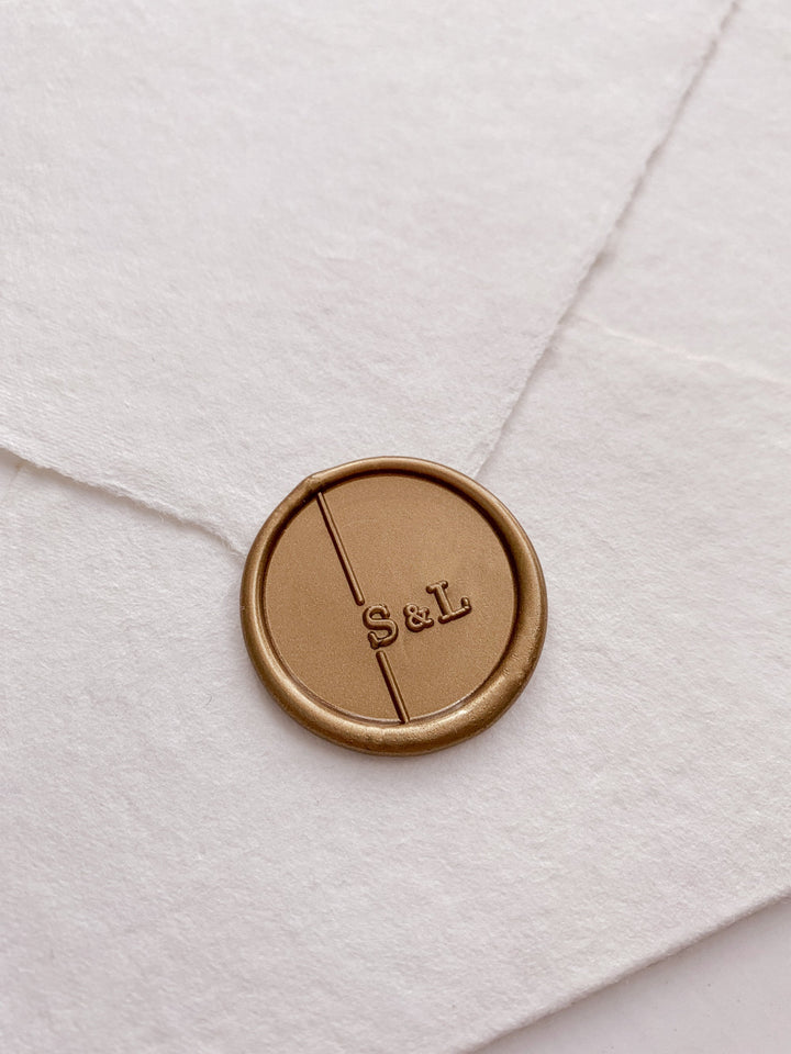 Modern monogram gold wax seal on handmade paper envelope_side angle