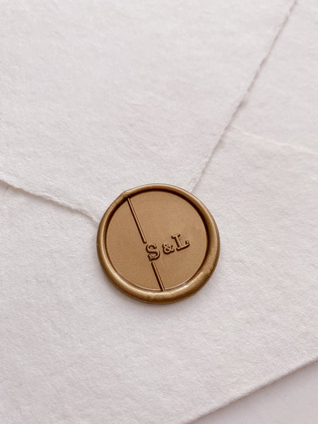 Modern monogram gold wax seal on handmade paper envelope_side angle
