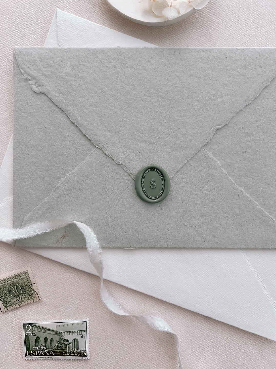 pine green custom initial mini oval wax seal on a light sage green envelope