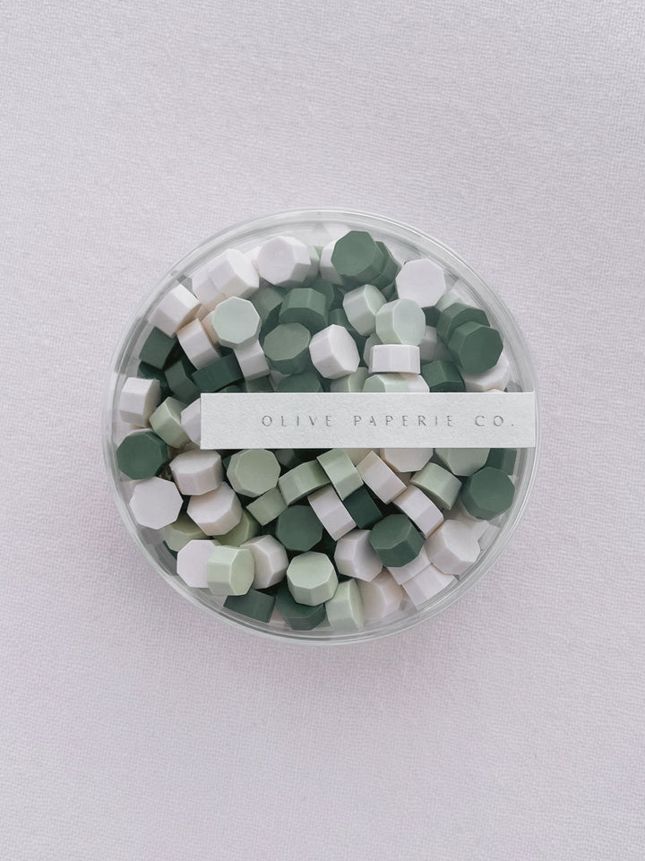 Assorted mix of pine green, light green and white sealing wax beads in a clear container box