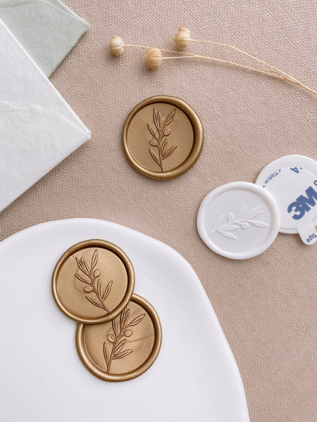Olive branch wax seals in gold and white and styled with dried flowers