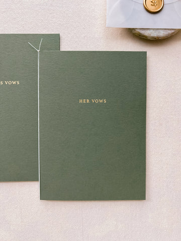 A set of two His and Her gold foil olive green card stock vow books in typeface font with fine white twine