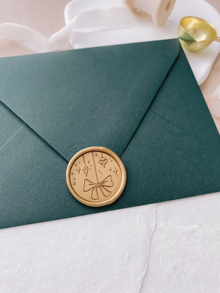 Holiday ornaments gold wax seal on dark green envelope