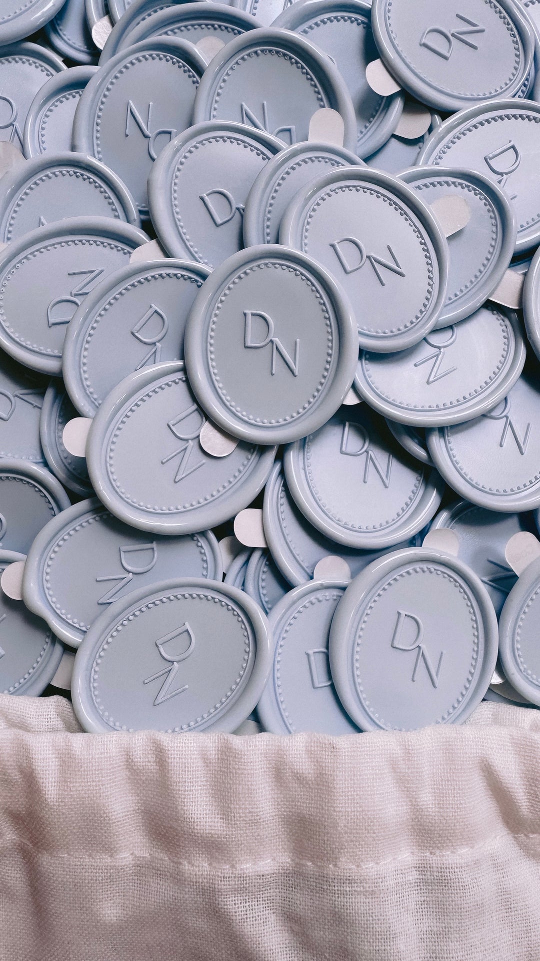 Light blue colored custom monogram oval wax seal stickers with a dotted border design