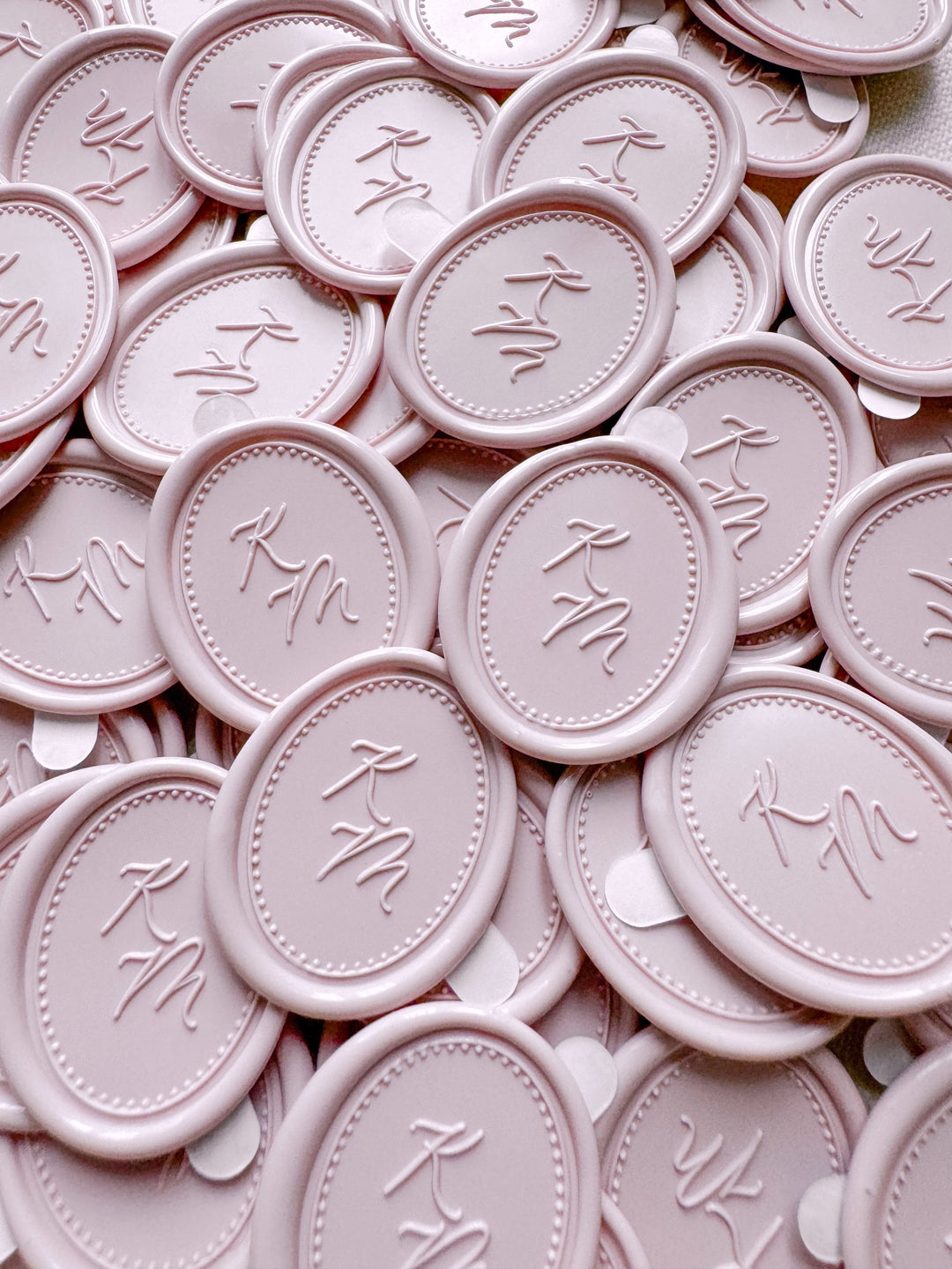 Dusty nude colored oval monogram wax seal stickers with adhesive backings