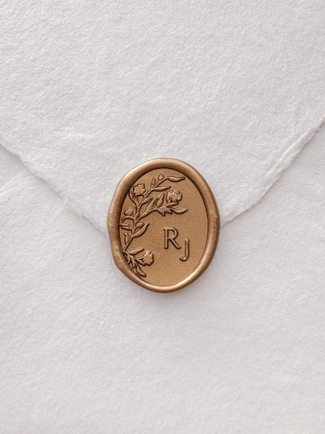Gold personalized floral monogram wax seal on a white envelope 