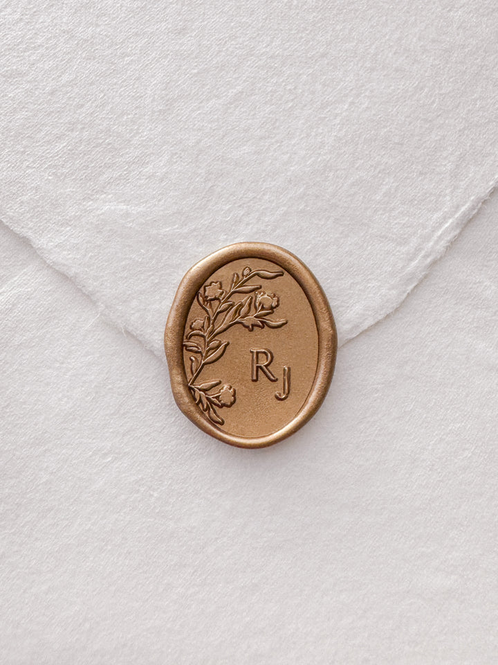 Gold personalized floral monogram wax seal on a white envelope 