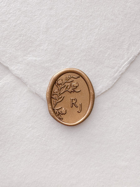 Gold personalized floral monogram wax seal on a white envelope 