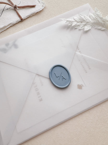 Oval monogram wax seal in color dusty blue on a vellum envelope