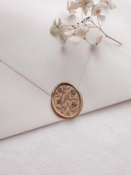 Floral pattern oval gold wax seal with 3D engraving details on a light beige envelope