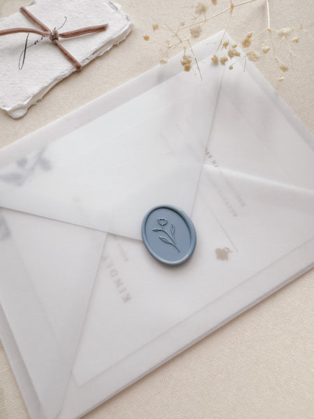 Oval simple flower wax seal in color dusty blue on a vellum envelope