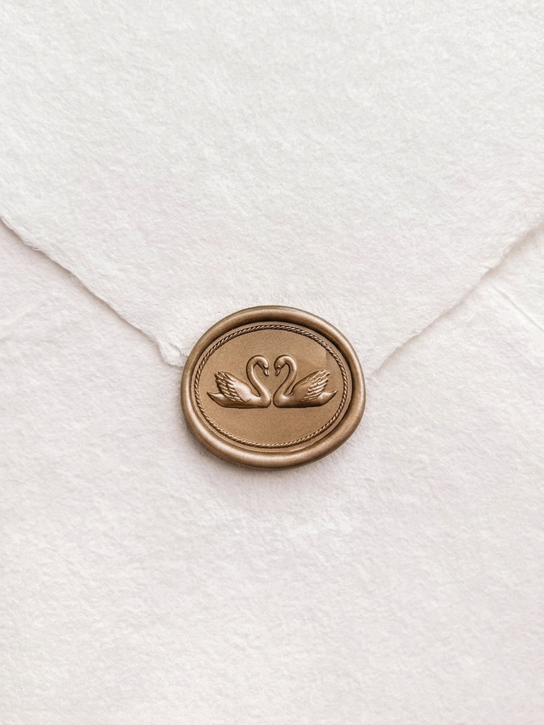 Gold double swans horizontal oval wax seal on a white handmade paper envelope