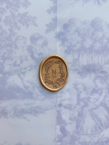 gold vintage crest custom monogram wax seal on a blue vintage print vellum jacket