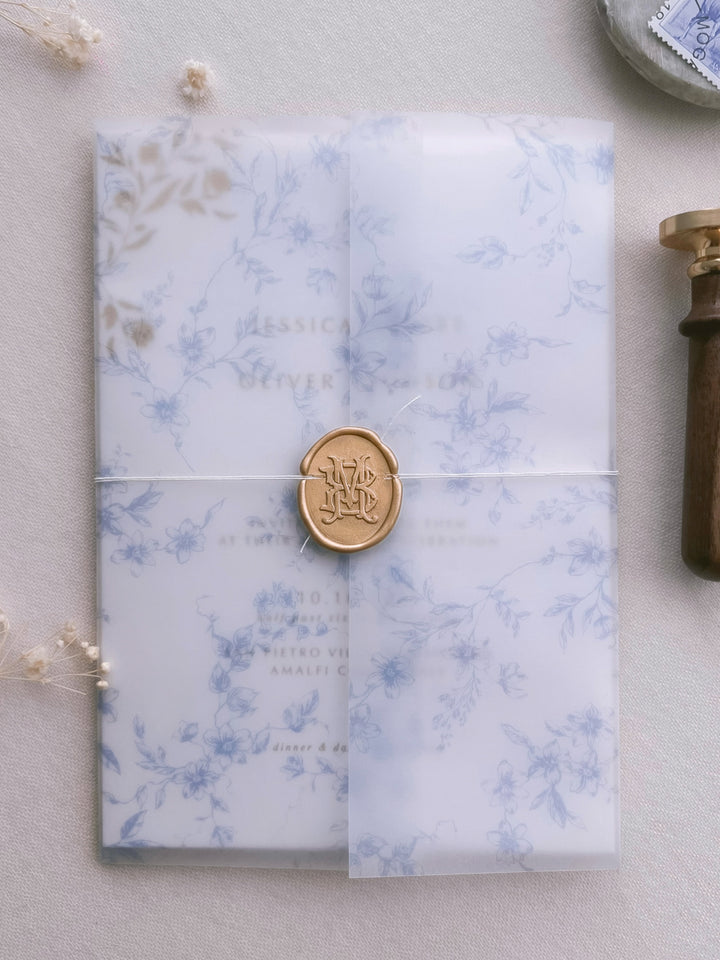 light gold vintage interlocked monogram wax seal on a blue floral print vellum jacket