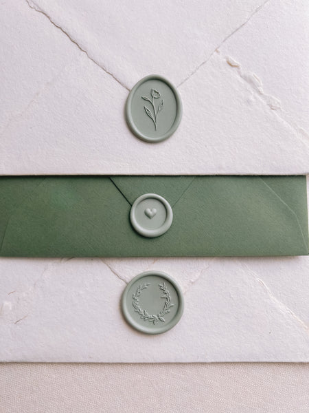 pale sage colored wax seals on white and green envelopes