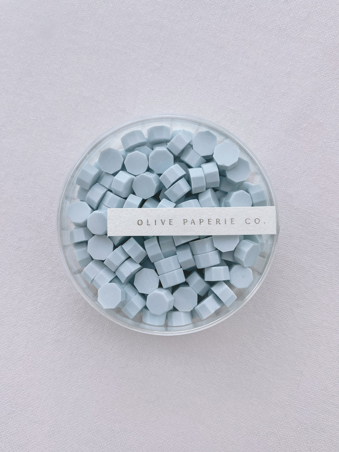 Light blue sealing wax beads in a clear container box