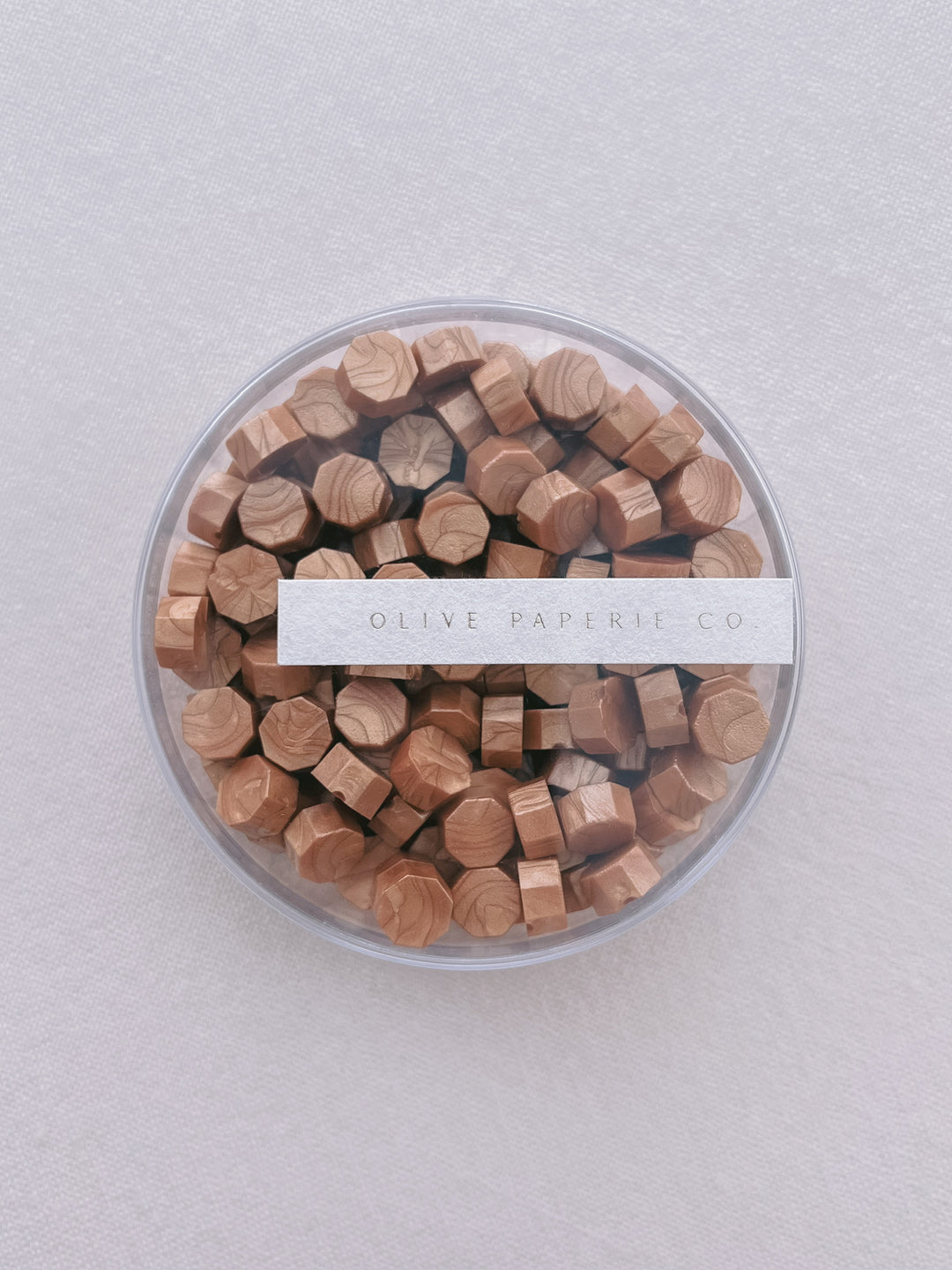 Gold sealing wax beads in a clear container box