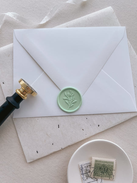 Light green eucalyptus bouquet design wax seal on a white envelope