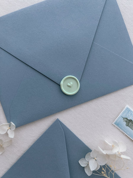 Light peppermint green 3D heart design mini wax seal on a dusty blue envelope