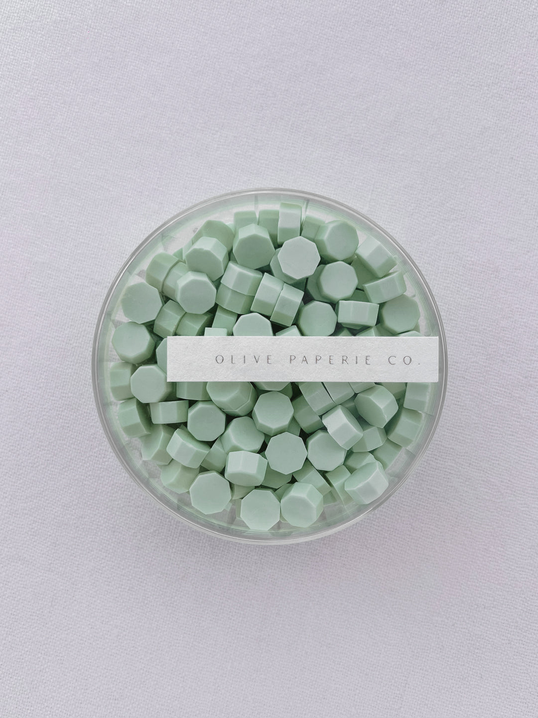 Light green sealing wax beads in a clear container box