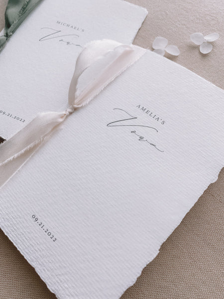 A set of two His and Her personalised handmade paper wedding vow books in calligraphy script with one tied with nude colored silk ribbon and the other tied with olive colored silk ribbon