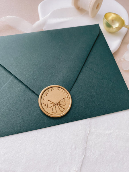 Ribbon bow gold wax seal on dark green envelope