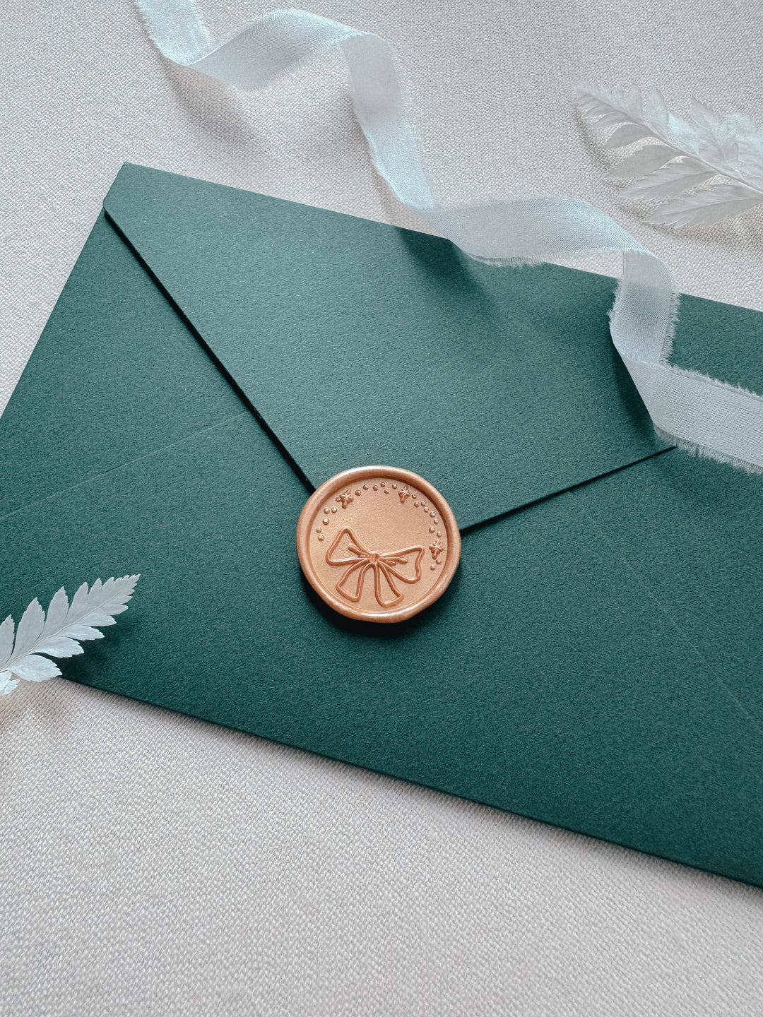 ribbon bow and sparkle holiday wax seal on Christmas card envelope