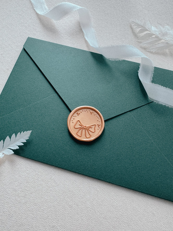 ribbon bow and sparkle holiday wax seal on Christmas card envelope