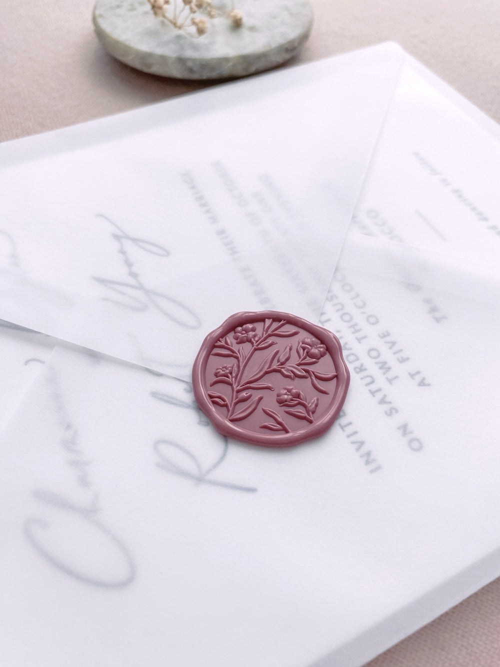 Dusty rose colored floral wax seal on vellum wedding invitation envelope 