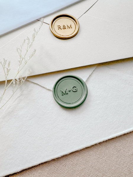 Sage green and light gold custom monogram wax seals with a dotted border design 