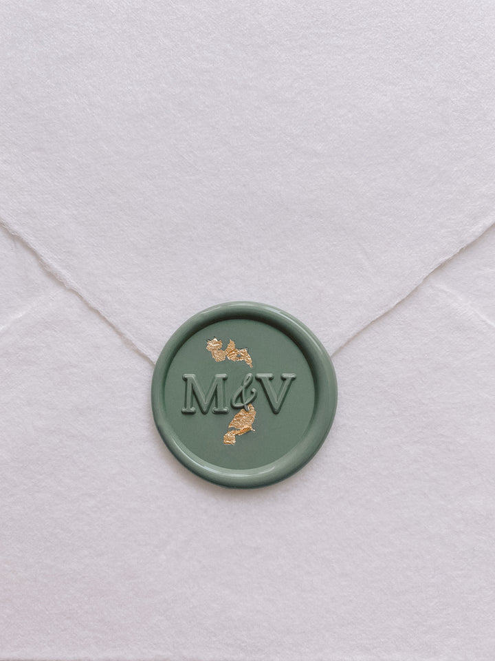 modern monogram wax seal in sage green embellished with gold leaf on handmade paper envelope_front angle