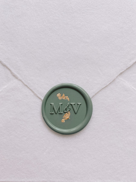 modern monogram wax seal in sage green embellished with gold leaf on handmade paper envelope_front angle