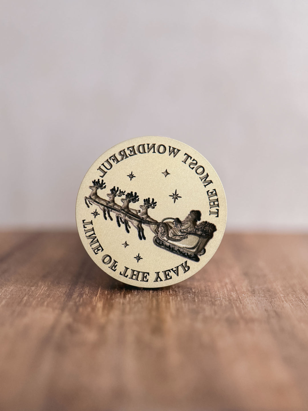 Santa sleigh wax seal stamp, showing the round brass stamp head engraved with reindeer, sleigh and The Most Wonderful Time of the Year lettering.