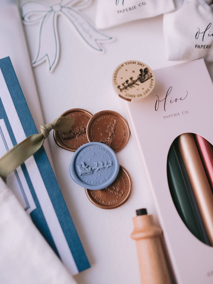 Dusty blue and antique bronze Santa sleigh Christmas wax seals styled with festive sealing wax sticks, Christmas cards and gift tags