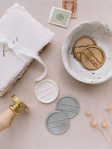 Gold, off-white and sage green save our date calligraphy script wax seals styled with a strand of white silk ribbon and wax seal stamp with wooden handle