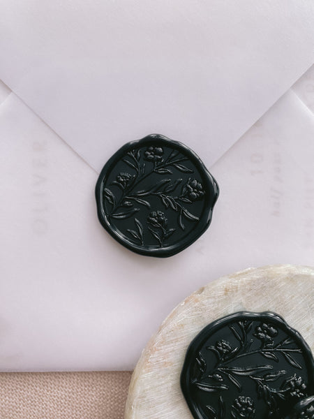Black floral wax seals on a vellum envelope