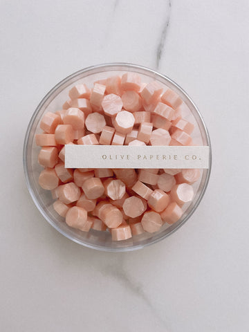a box of light peach color sealing wax beads