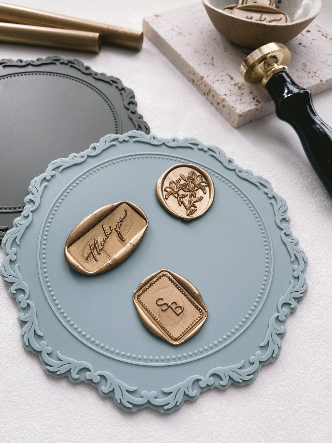 Silicone mat in charcoal and pale blue with gold wax seals