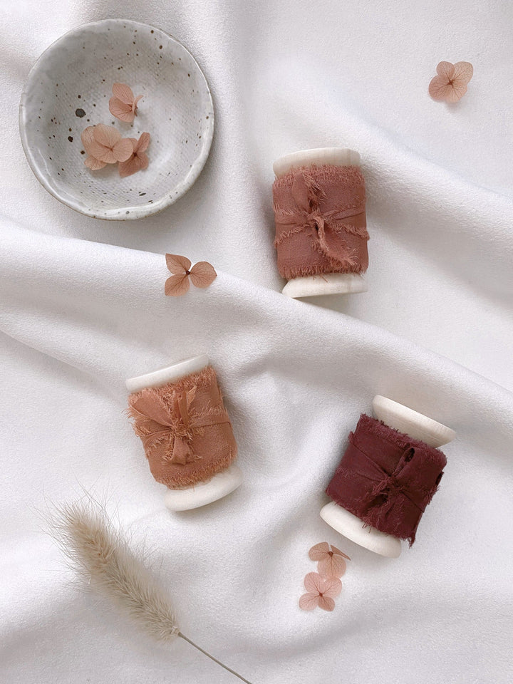 1 inch raw edge silk ribbon on wooden spools in color Clay, Terracotta, and Wine