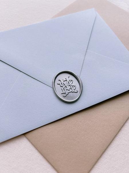 vintage interlocked monogram silver wax seal on blue envelope 