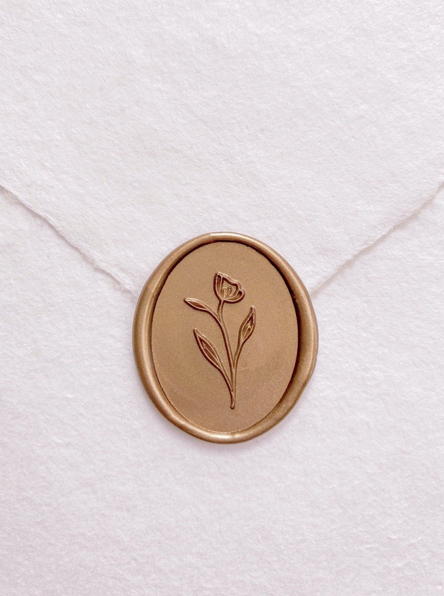 Simple flower oval wax seal in gold on handmade paper envelope