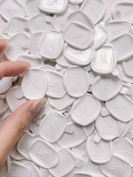 Soft white rectangular monogram wax seals with adhesive backings