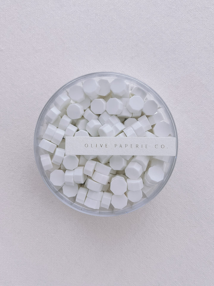 Soft white sealing wax beads in a clear container box
