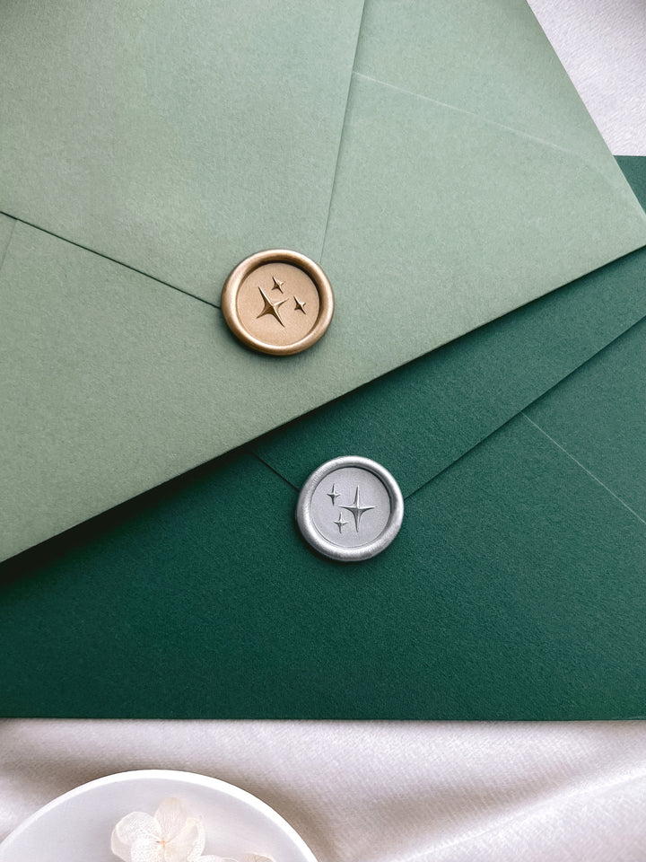 Gold and silver stars design mini wax seals on green envelopes